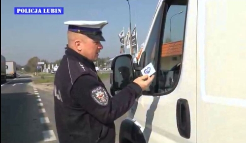 Policjant wręcza kierowcy ulotkę akcji, źródło: www.policja.pl