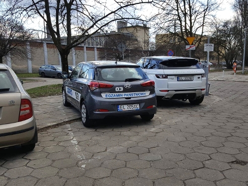 Samochód egzaminacyjny przed łodzkim WORD na ulicy Smutnej, w tle widzimy mury zakładu karnego.