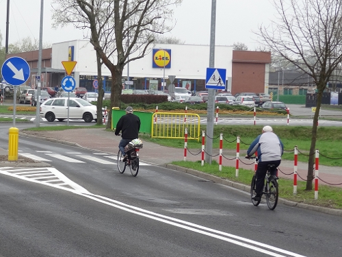 Niprawidłowo jadący rowerzyści. Obok nich po prawej stronie znajduje się ścieżka rowerowa, z której powinni korzystać., źródło: materiały własne www.info-car.pl